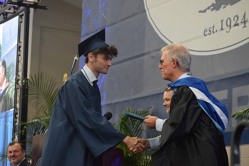 Ryan Newhams accepts the Achievement Award from James Connor, the interim head of school. The award is chosen by faculty for a student who shows tremendous growth and development during his or her time at ODA.