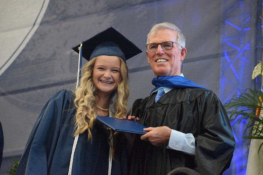 Brooke East smiles big after accepting her diploma from James Connor, the interim head of school.