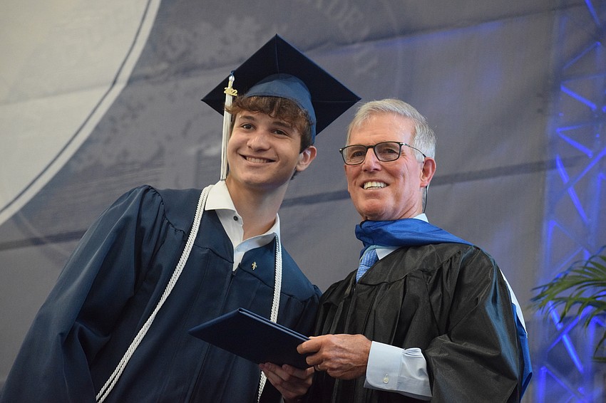 Anthony Gaukhman accepts his diploma from James Connor, the interim head of school.