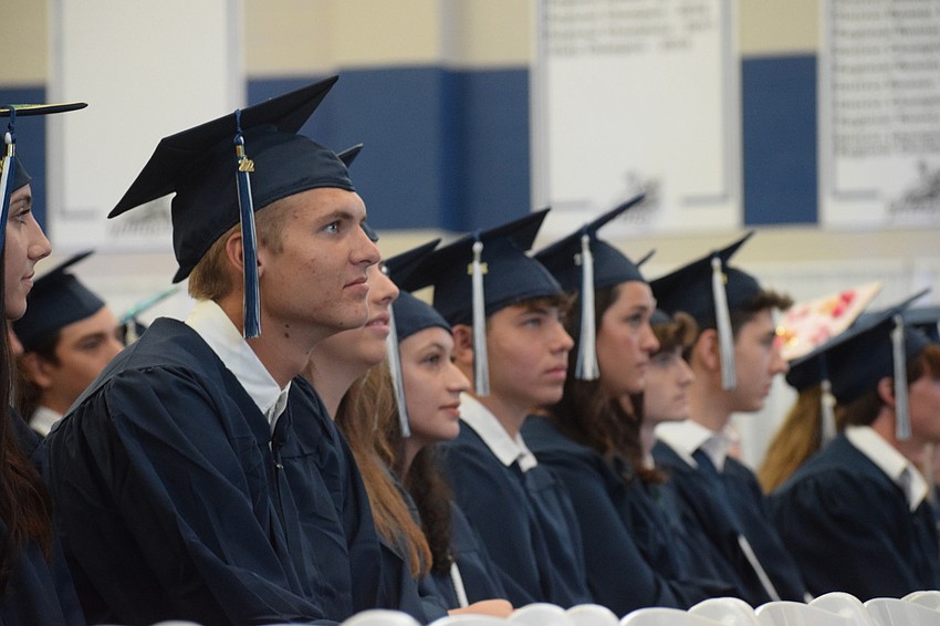 Graduates patiently wait to walk the stage and accept their diploma.