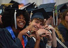ODA seniors Aaliyaa Genat and Anthony Gaukhman make hearts with their hands as they enjoy their graduation ceremony.