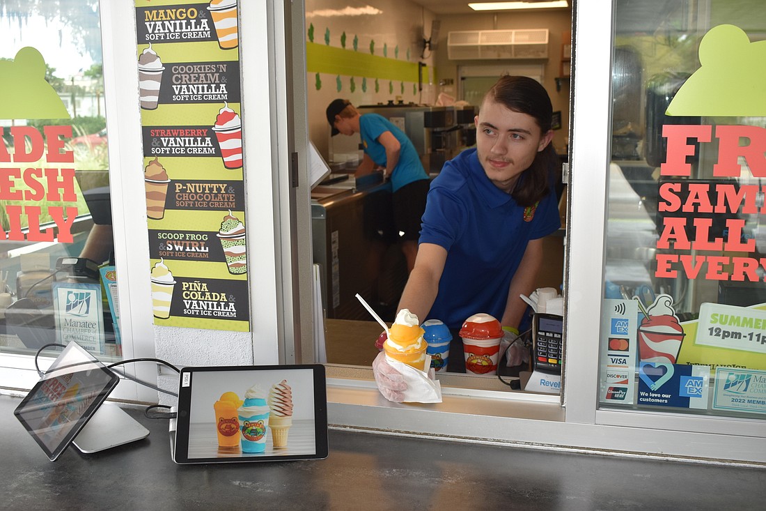 Employee Tyler Simons hands out a Jeremiah&#39;s Gelati featuring mango Italian ice and vanilla soft ice cream. (Photo by Ian Swaby)