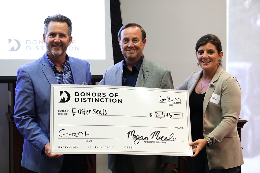 Representatives from various nonprofits accepted checks with Donors of Distinction members.