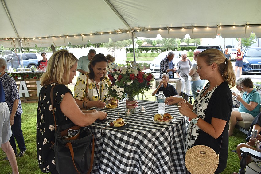 Tidewell Hospice employees Tami Caruso, Maria Paliotta and Kristen Franke, chat over barbecue during the open house.