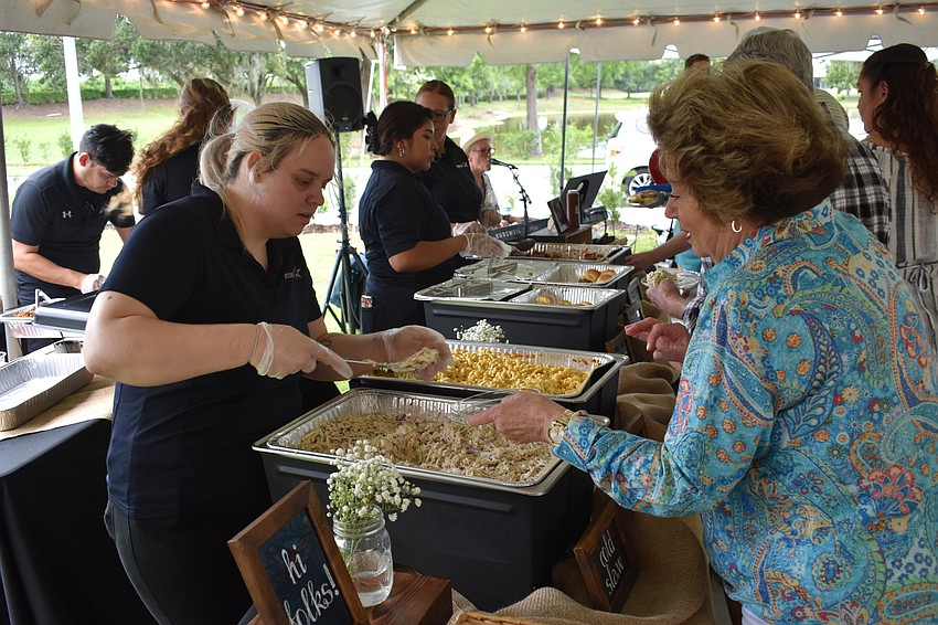 Sabrina Abbott of West Bradenton spoons some coleslaw for Tricia Brocco of Country Club.