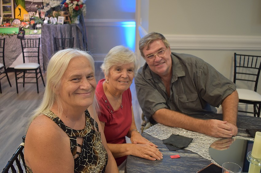 Sheryl Perkins current president of the Lakewood Ranch Gardening Club, Phyllis Weber, former president, and Perkins' husband Sunny Thompkins, take a seat in the dining hall.