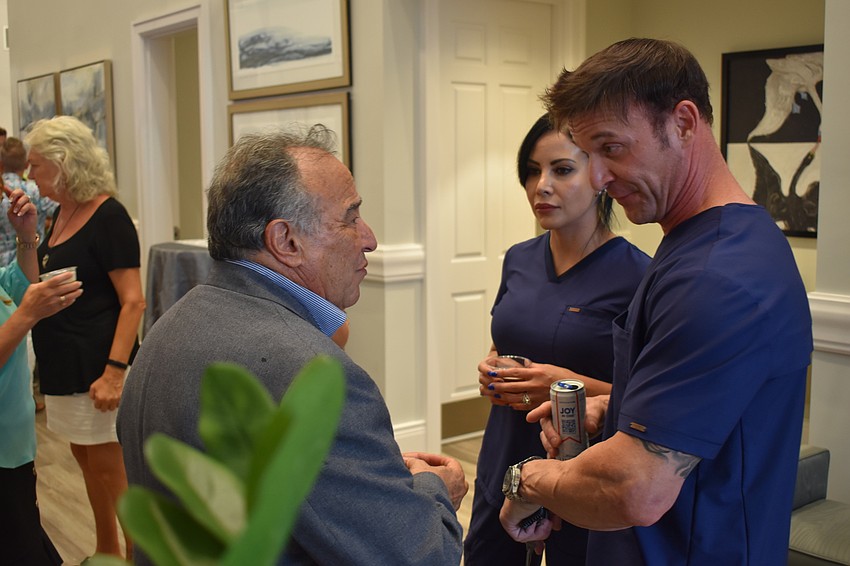 Family Service Counselor Al Connizzo chats with Jeymie and Dominic Sorrentino, who lent the parking lot of their business next door, Affinity Wellness 4 Life, for the event.