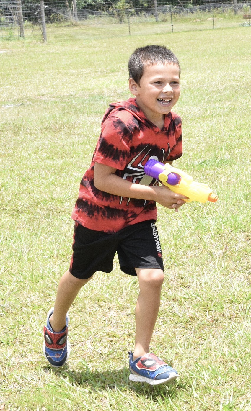 Bjorn Welde-Thomas, who is 6, makes a run for it as other campers try to squirt him with water guns.