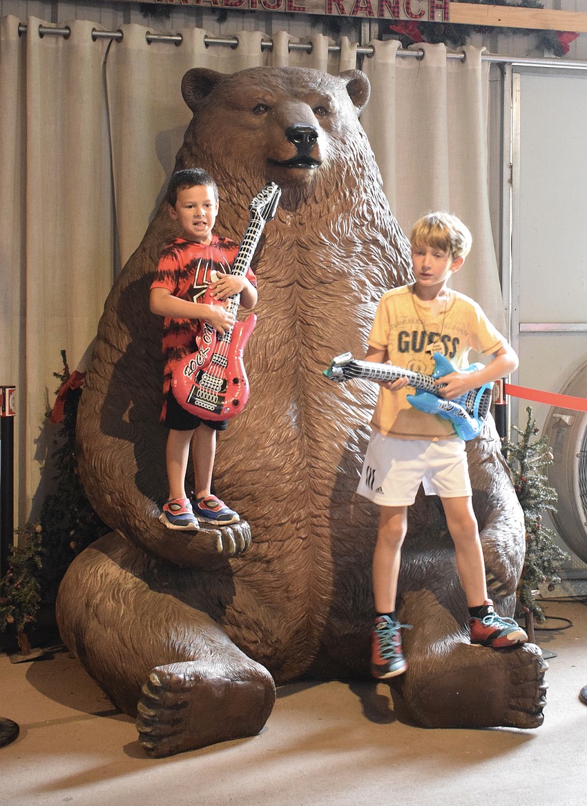 Bjorn Welde-Thomas, who is 6, and Mateo Murariu, who is 8, rock out with blow-up guitars while other campers sing karaoke.