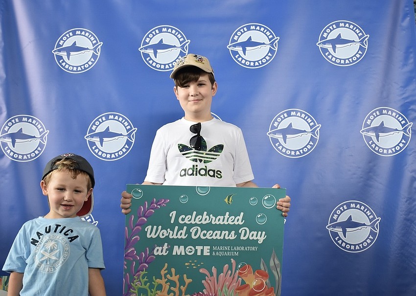 Grayson and Matthew Powell in front of Mote's step and repeat.