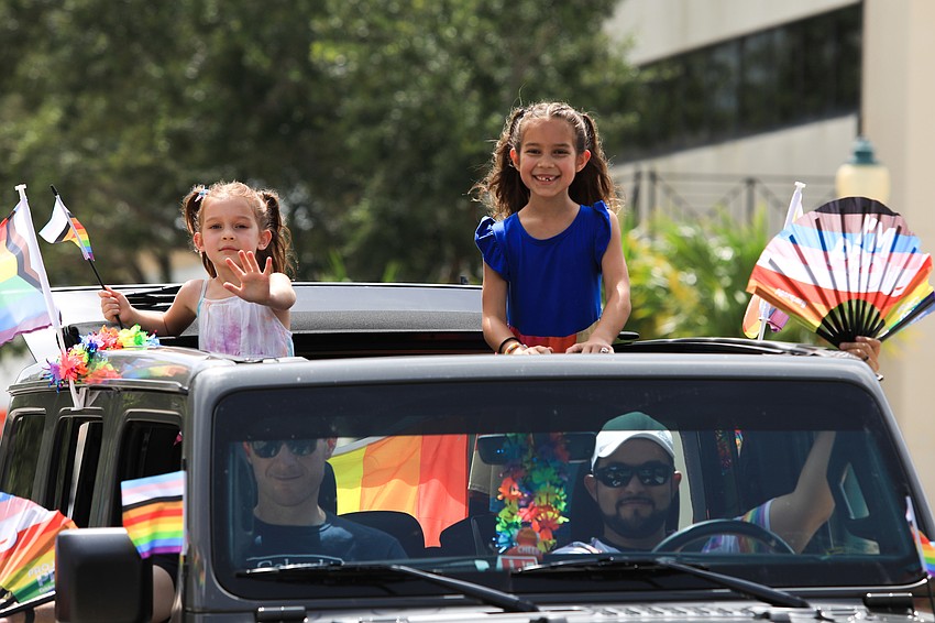 Sienna and Cataline Campbell wave from the top of their car.
