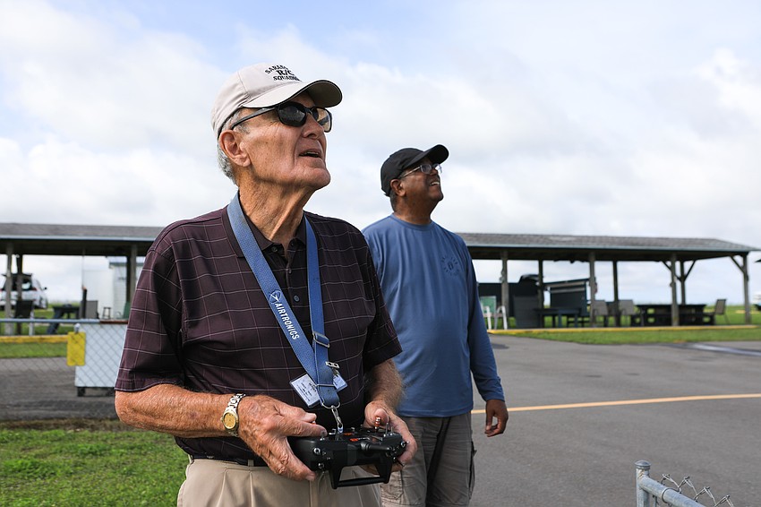 Al Jensen maneuvers his plane throughout the field while Anthony Lassiter keeps watch.