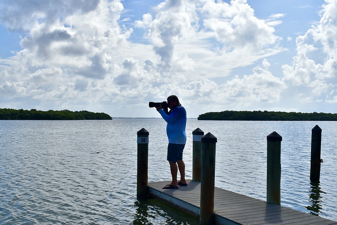 John Harkness takes the majority of his pictures from this dock behind his Longboat Harbour condominium. (Photo by Lesley Dwyer)