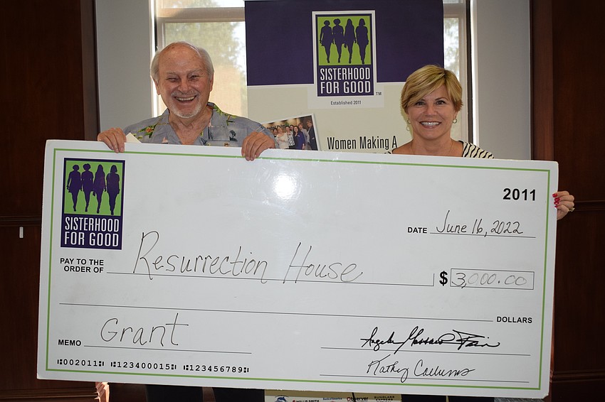 Bill Wilson, the development director of Resurrection House, accepts a grant from Sisterhood for Good founder Angela Massaro-Fain.