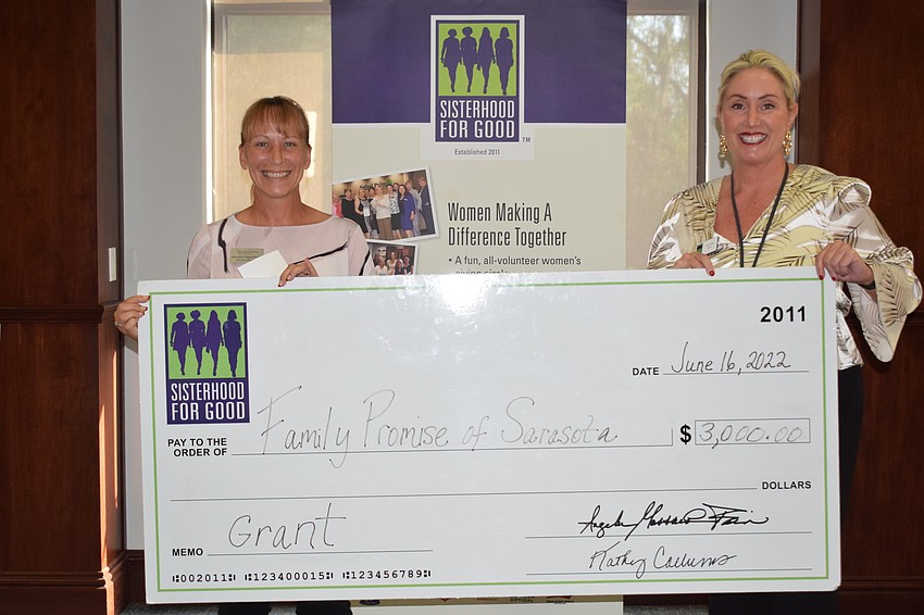Family Promise Executive Director Jennifer Fagenbaum shows off the $3,000 grant she receives from Sisterhood for Good's Tracy Wolfe.