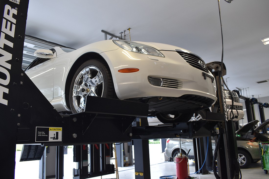 A car is suspended in the air for maintenance at Christian Brothers Automotive. (Photo by Ian Swaby)