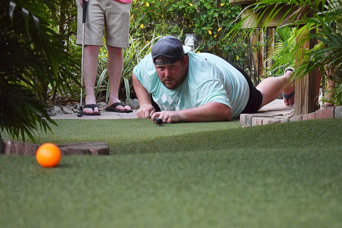 Chris McComas, the co-founder of MVP Sports  and Social, hopes he can get a hole-in-one while using the putter as a pool stick. (Photo by Liz Ramos)
