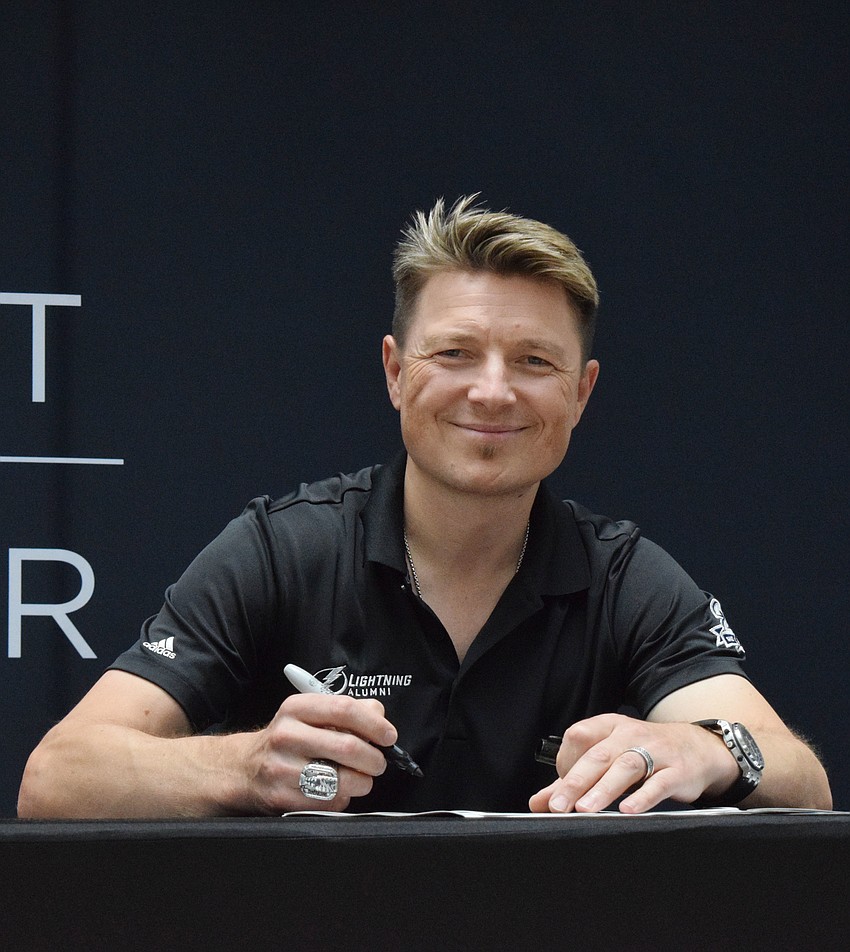 Ruslan Fedotenko, a former Tampa Bay Lightning player, signs autographs for a line of fans during Dad's Day Block Party at the Mall at UTC.