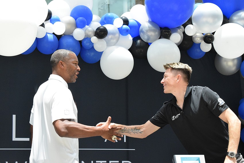 Alex Smith, a former tight end for the Tampa Bay Buccaneers, greets Ruslan Fedotenko, a former player for the Tampa Bay Lightning. Fedotenko and Smith were at the Dad's Day Block Party to sign autographs.