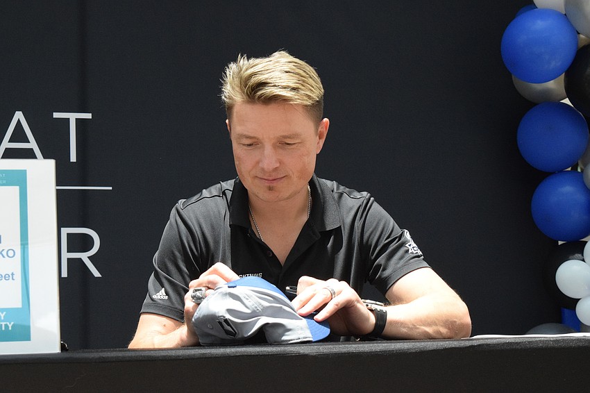 Ruslan Fedotenko, a former player for the Tampa Bay Lightning, signs a hat for Sarasota's Darian Trice-Farrelly, who is 6,