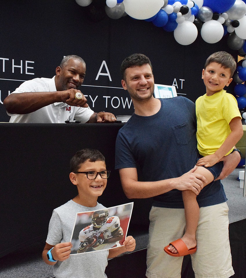Alex Smith, a former player for the Tampa Bay Buccaneers, shows off his Super Bowl ring to Parrish's Simon Cannatello, who is 7, and his father, Christian Cannatello, and 5-year-old brother Walter Cannatello.