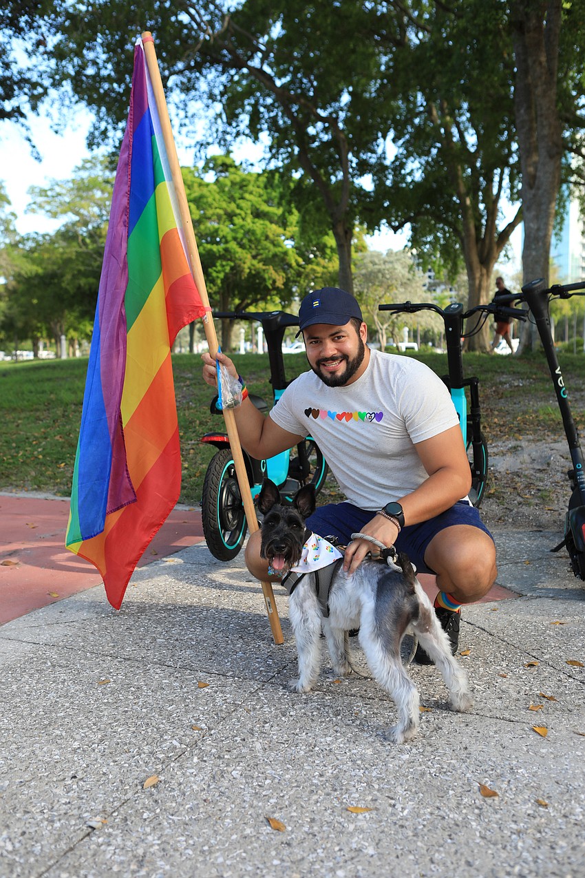 Christian Saruff and Mac the dog walk with a pride flag.