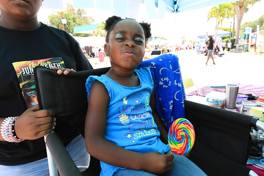 Alia Cherry scrunches through face paint done by Kari Bunker.