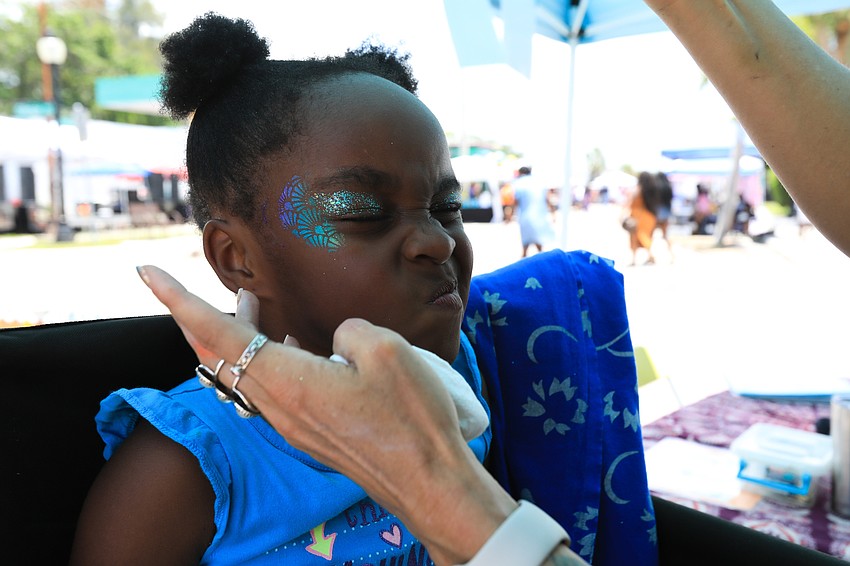 Alia Cherry scrunches through face paint done by Kari Bunker.