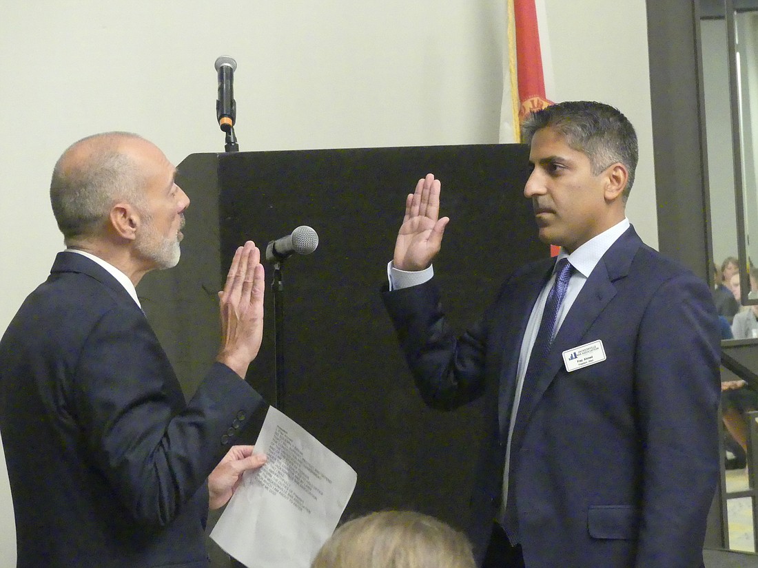 State Supreme Court Justice Alan Lawson administers the oath of office to 2022-23 Jacksonville Bar Association President Fraz Ahmed.