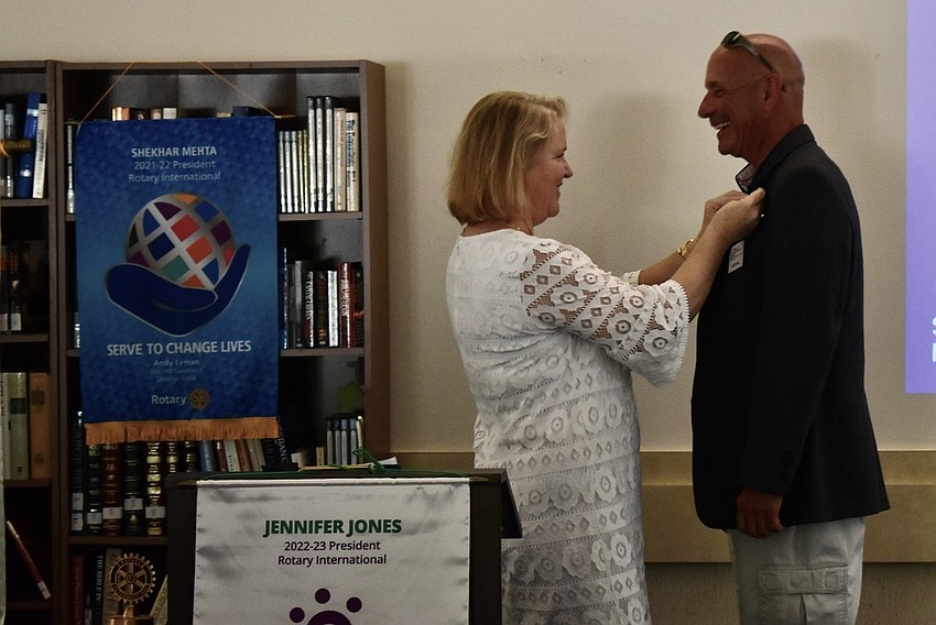 Teresa Taft pins Jeff Driver as the club's new president.