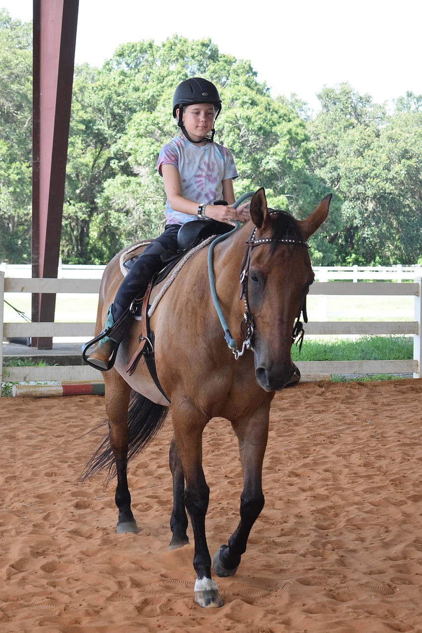 Mila Reinisch, who is 10, gets Gypsy to canter around the arena. Reinisch says Gypsy is an energetic and sweet horse.