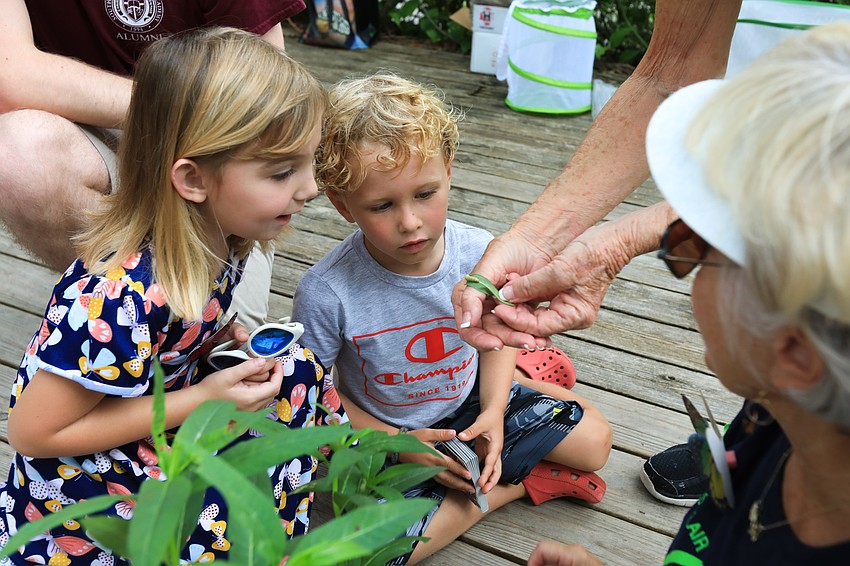 Elyse Germeroth and Kai Frisoli admire the small caterpillar.