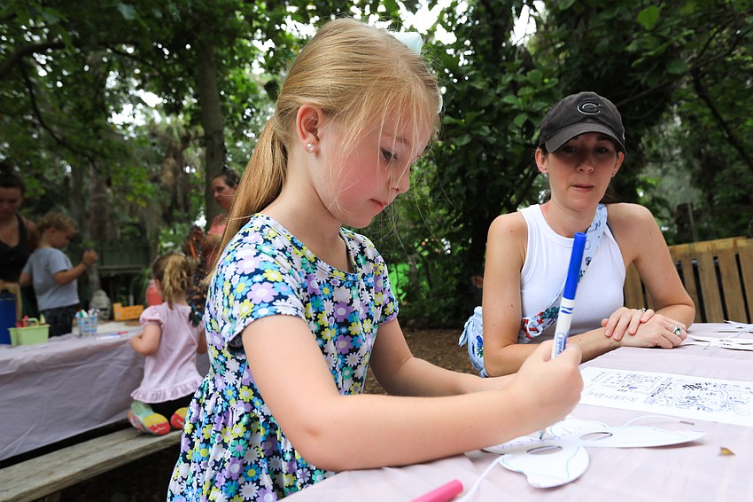 Brielle and Shay Coffey work on their butterfly mask.