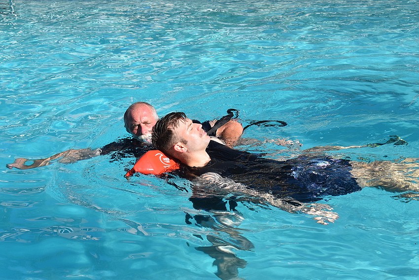Jell Bullock pulls Ryan Corso from one end of the pool to another during an annual water rescue training.