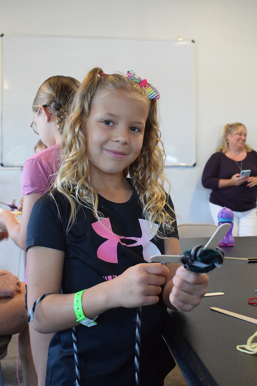 Savvy Lough chooses white, teal and black yarn to make her craft because she loves those colors.