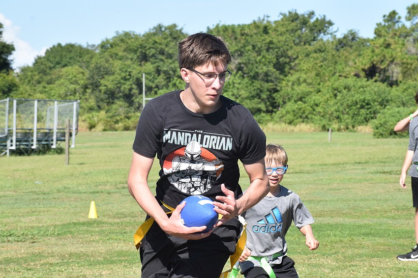 Adden Adorno, a counselor in training, takes the ball down field trying to score a touchdown.