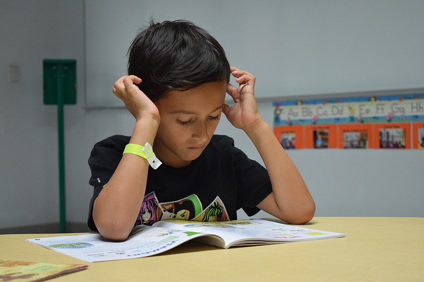 Carson Feldman reads to himself before he and other campers go to do arts and crafts.