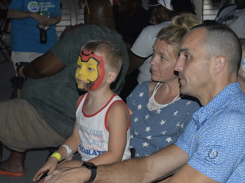 Cohen Cooper, 4, his mother Missy Cooper, and his father Kevin Cooper, sit near the balcony in the VIP area in as they await the fireworks.