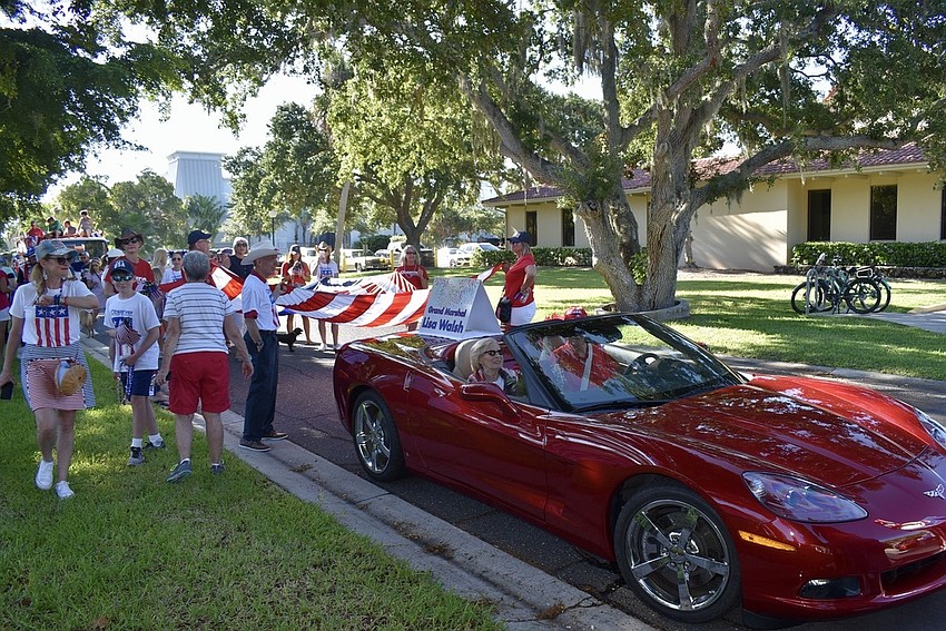 The parade kicks off with Lisa Walsh in a red Corvette.
