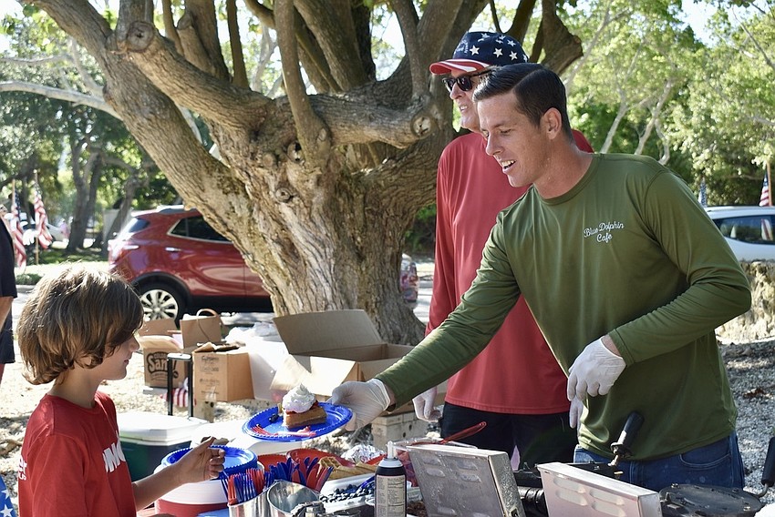 Robbie Ball dishes out waffles after the parade.
