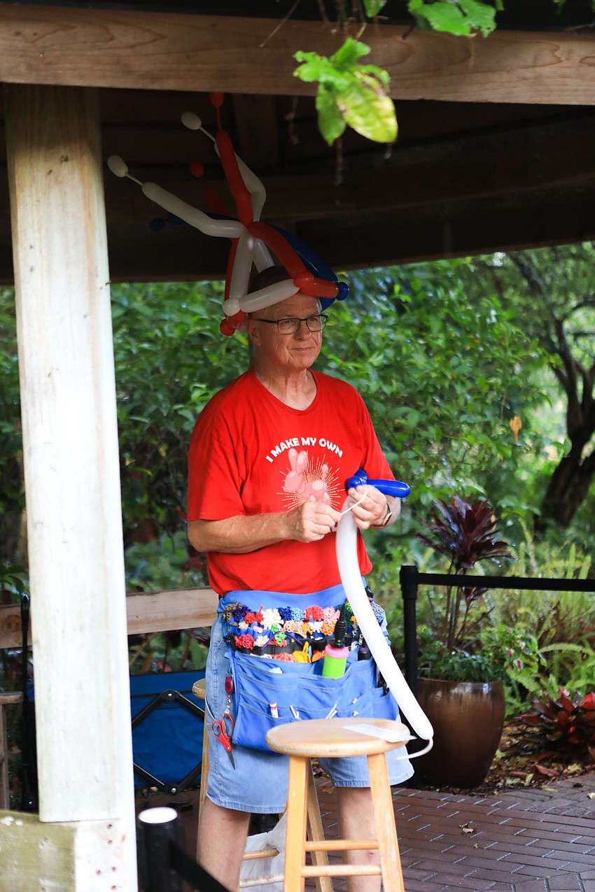 Gregory Art blows up balloons for families.