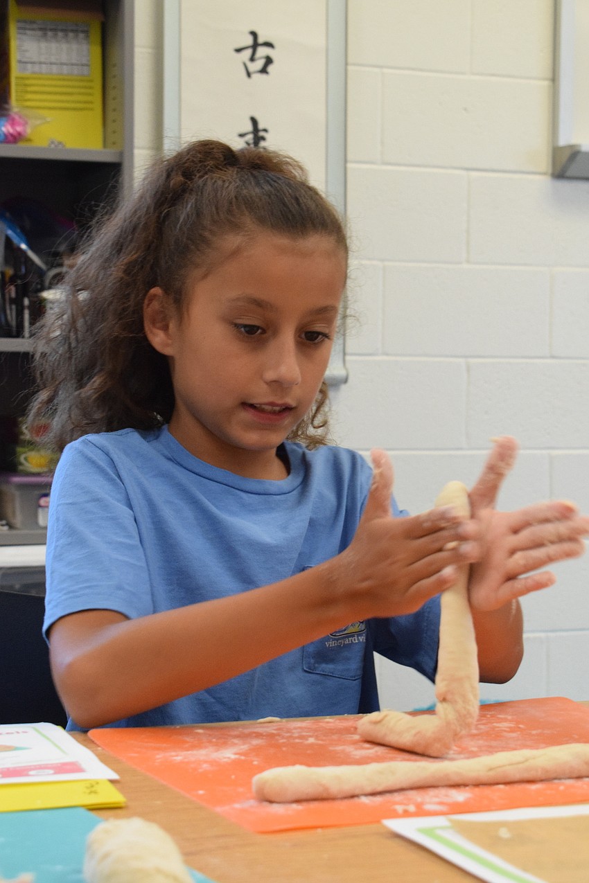 Emilia Costello, who is 10, rolls out her dough. Costello wanted to participate in the Crazy Cooks Camp because she wants to be on 