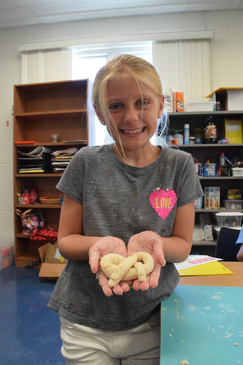 Paige Royce, who is 8, shows off the pretzel she made.