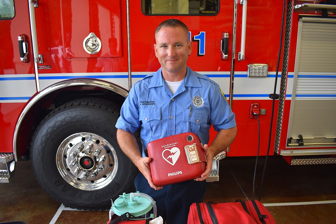 Firefighter Ryan Berggren holds the automated defibrillator used by EMTS such as himself; paramedics are allowed to perform defibrillation manually. (File photo)