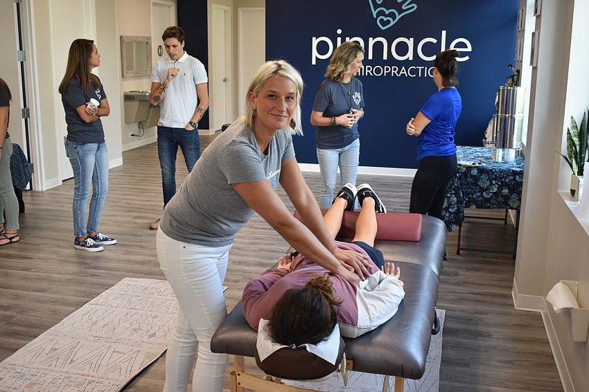 Sabrina Malloch, a licensed massage therapaist with Whitewave Bodywork, demonstrates her skills to 13-year-old Izaak Miller of Sarasota.