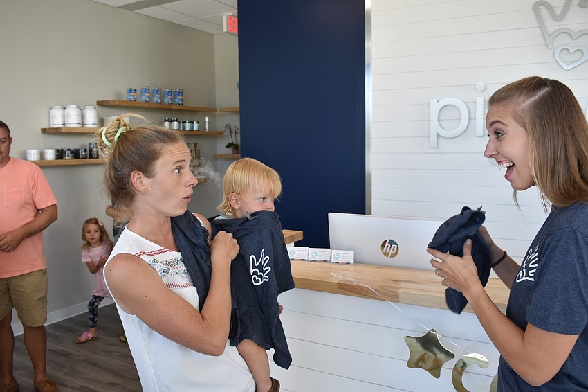 Myakka City's Savannah Hallum, and 18-month-old Avery Hallum, receive free t-shirts from Dr. Jordan Dieterle.