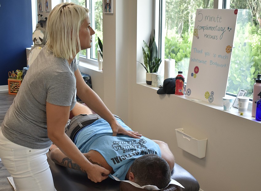 Sabrina Malloch, a licensed massage therapaist with Whitewave Bodywork, demonstrates her skills to Sarasota's Rob Seaman.