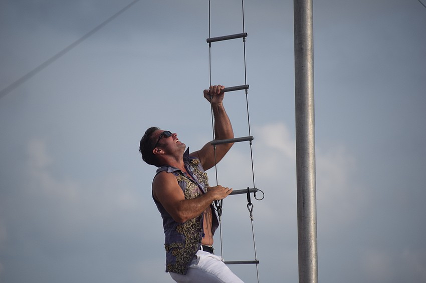 Highwire daredevil Blake Wallenda climbs a ladder about 60 feet above the ground to begin his walk toward the finish tower.