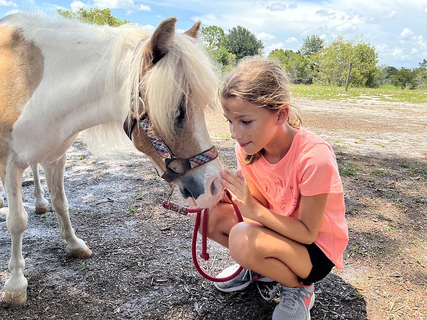 Brooklyn Zabikow, who is 11, gives kisses to Asher. 