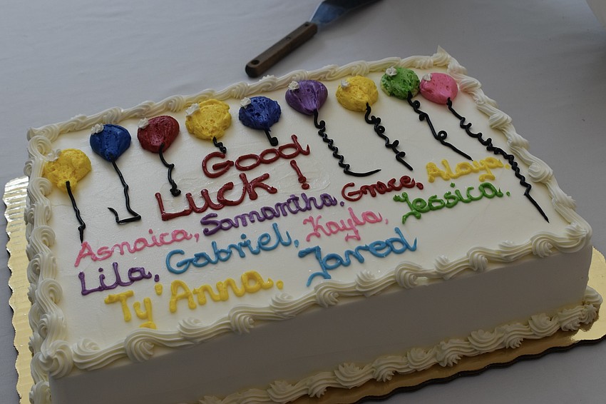 Congregation members celebrate the students with cake.